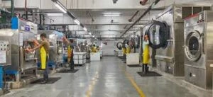 Operators managing commercial garment washing, dyeing, and fabric treatment machinery inside Feel It Creation's apparel processing unit.